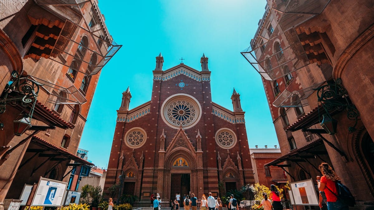 Tourists visiting St. Anthony of Padua Church in Istanbul on a sunny day.